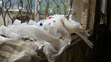成堆的生理食鹽水堆放在廢棄的衛生所，日曬雨淋